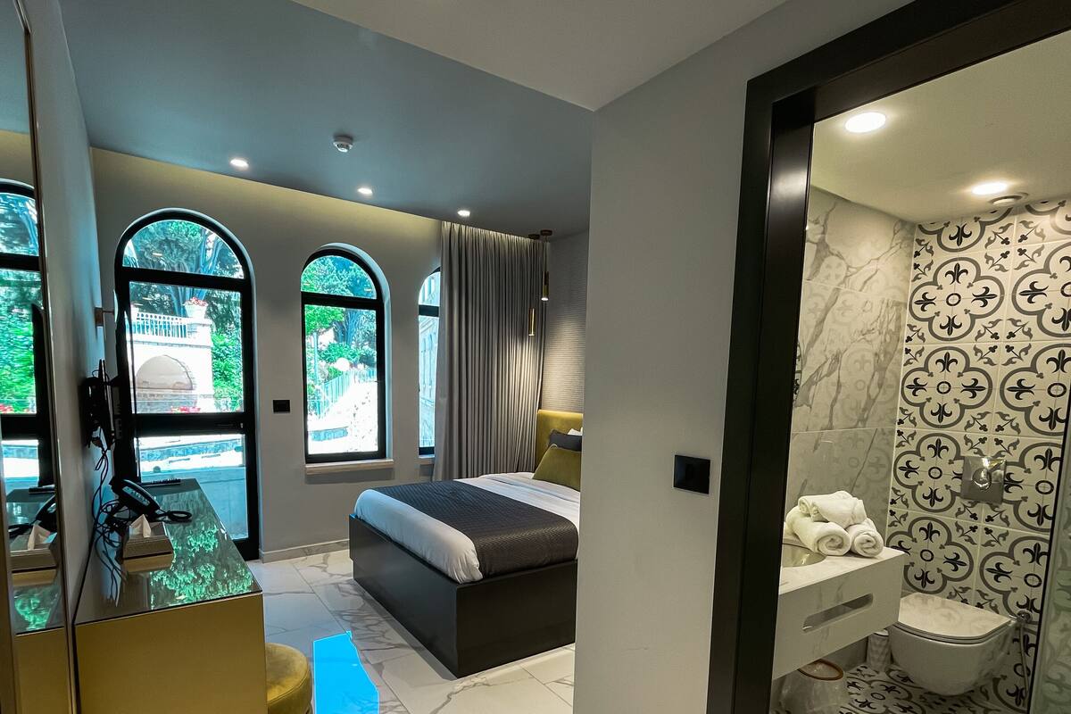 Une chambre d’hôtel moderne équipée d’un lit, d’un bureau et d’une salle de bain.