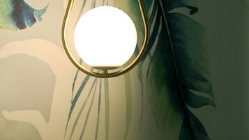 Een hanglamp met gouden frame hangt aan een plafond met bladmotief.