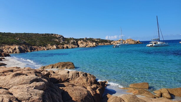 A coastal scene with clear turquoise waters, rocky shoreline, and sailboats. - T2 sea view apartment (Tizzano)