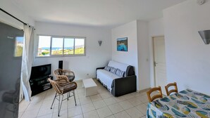 A compact living space with a TV, seating area, and a bed. - T2 sea view apartment (Tizzano)