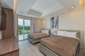 A modern hotel room with two beds, a desk, and a large window offering a view of greenery.