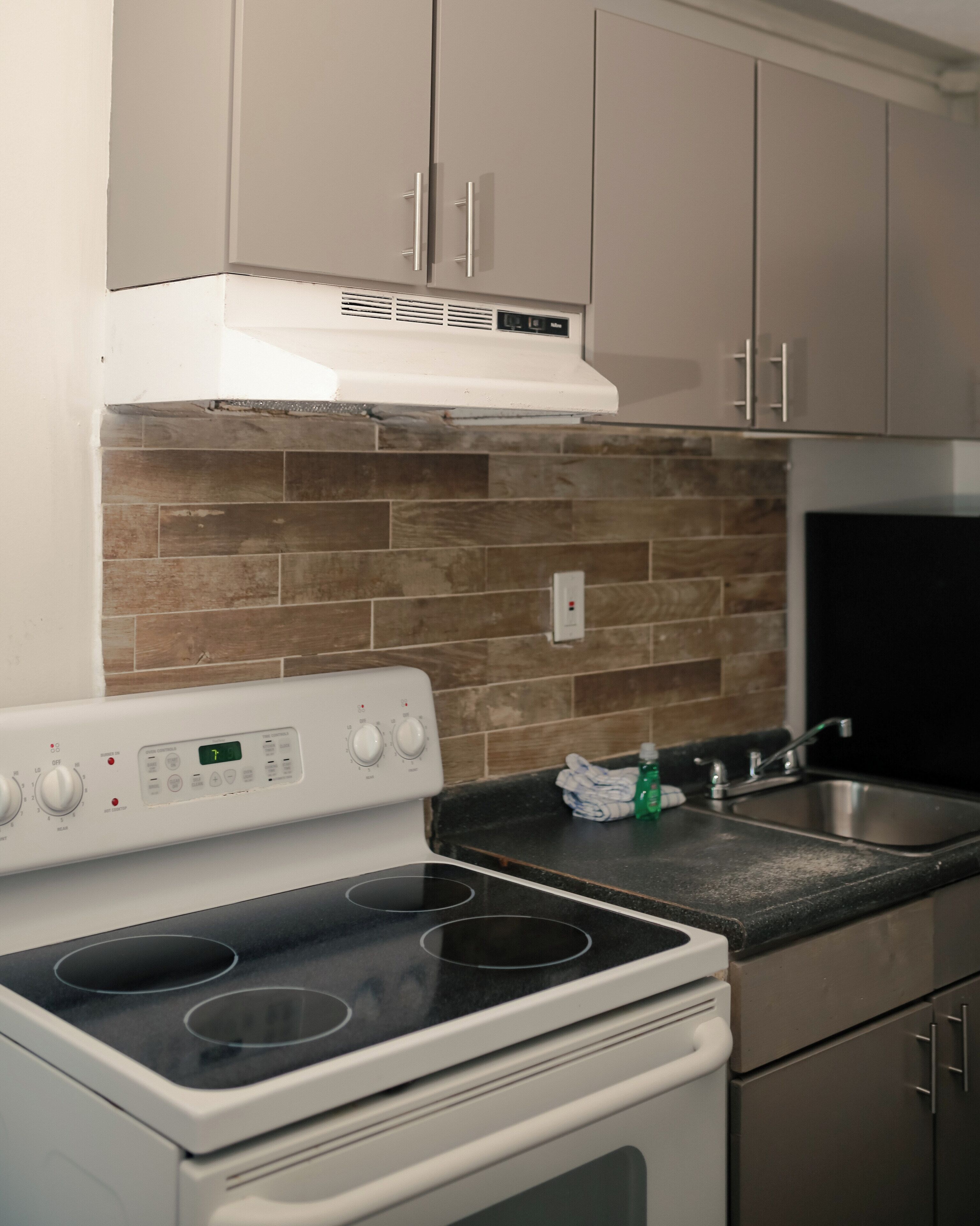 A kitchen with a stove, oven, and a black countertop.