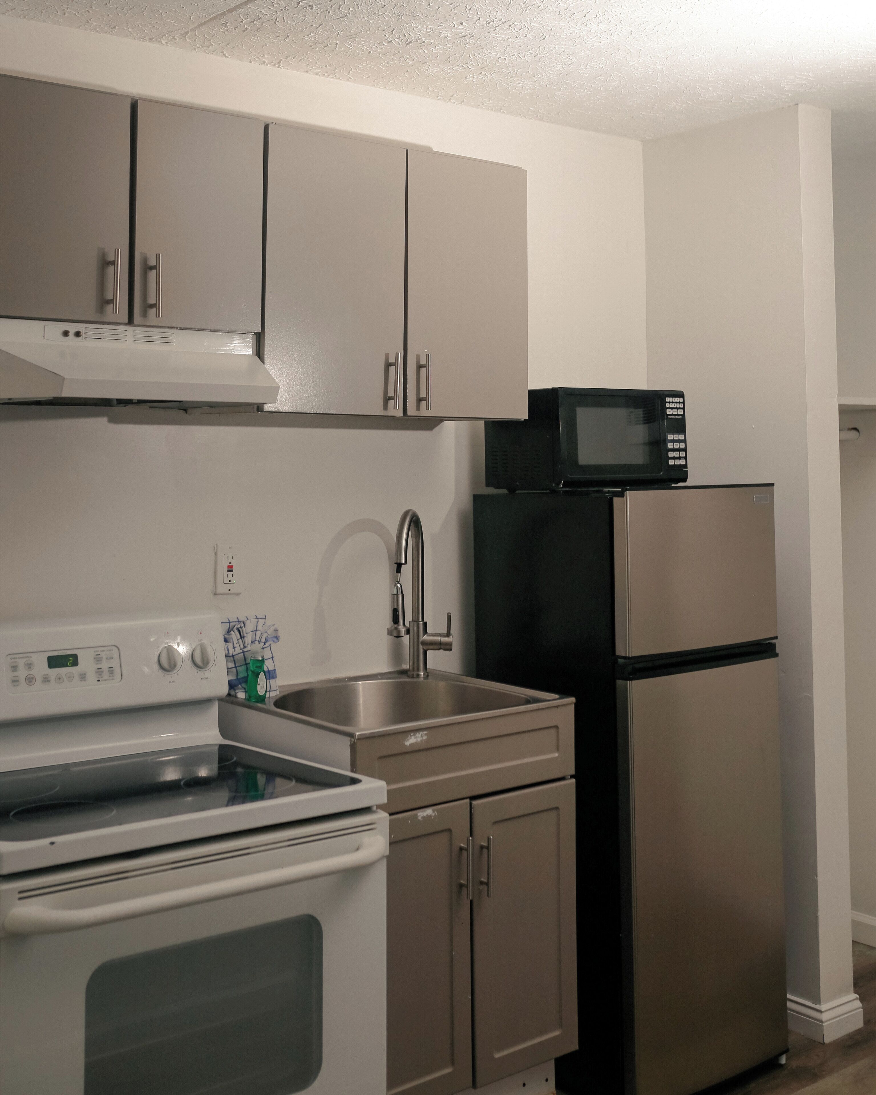 A kitchen with stainless steel appliances, including a stove, oven, microwave, and refrigerator.