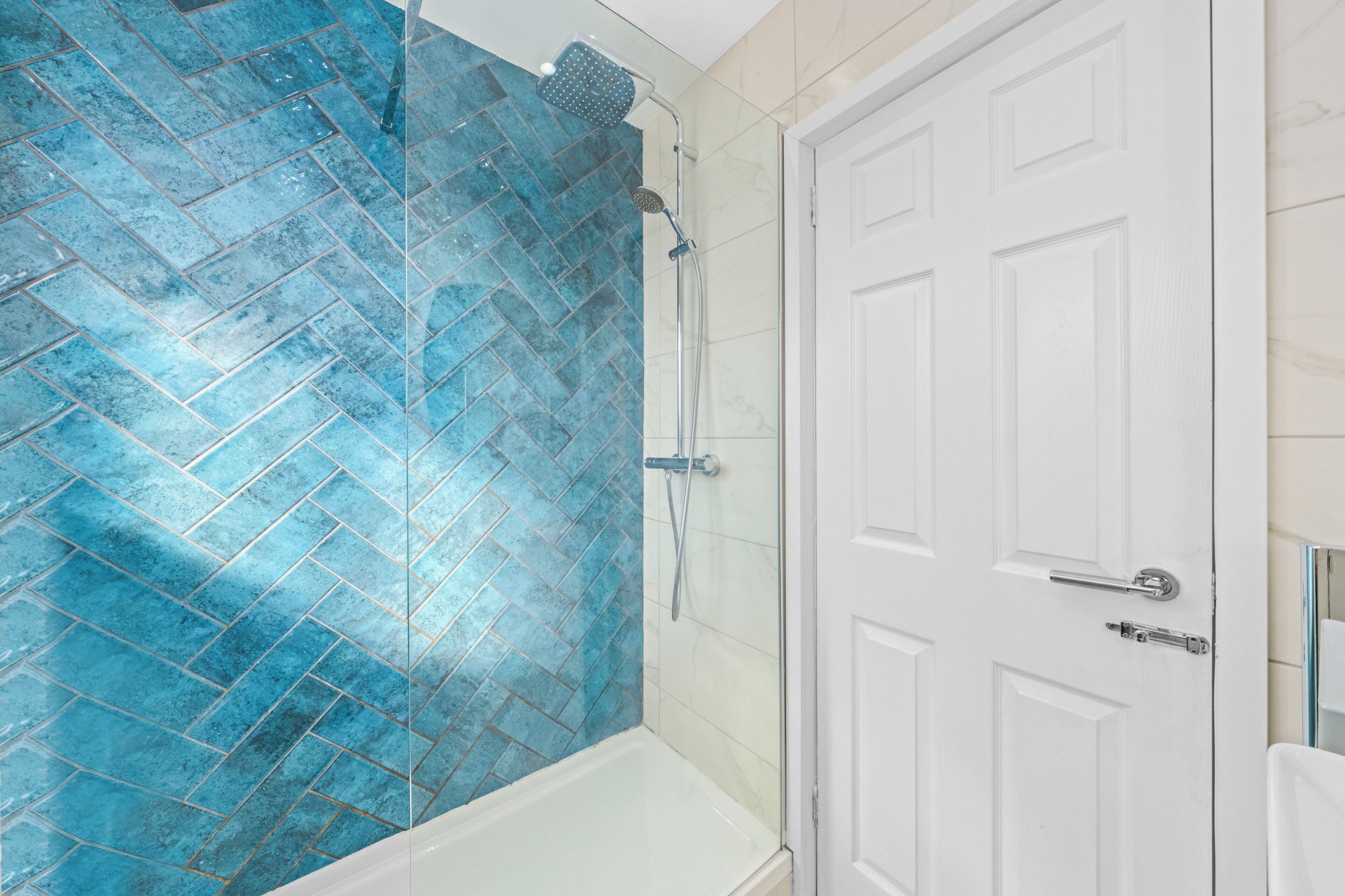 Un bagno con doccia, una porta bianca e una vasca da bagno.