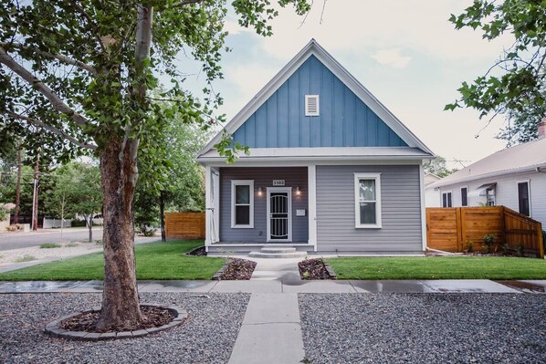 A single-story house with a gabled roof, a front porch, and a number "1102" on the door. - Updated Downtown Bungalow Centrally Located (Grand Junction)
