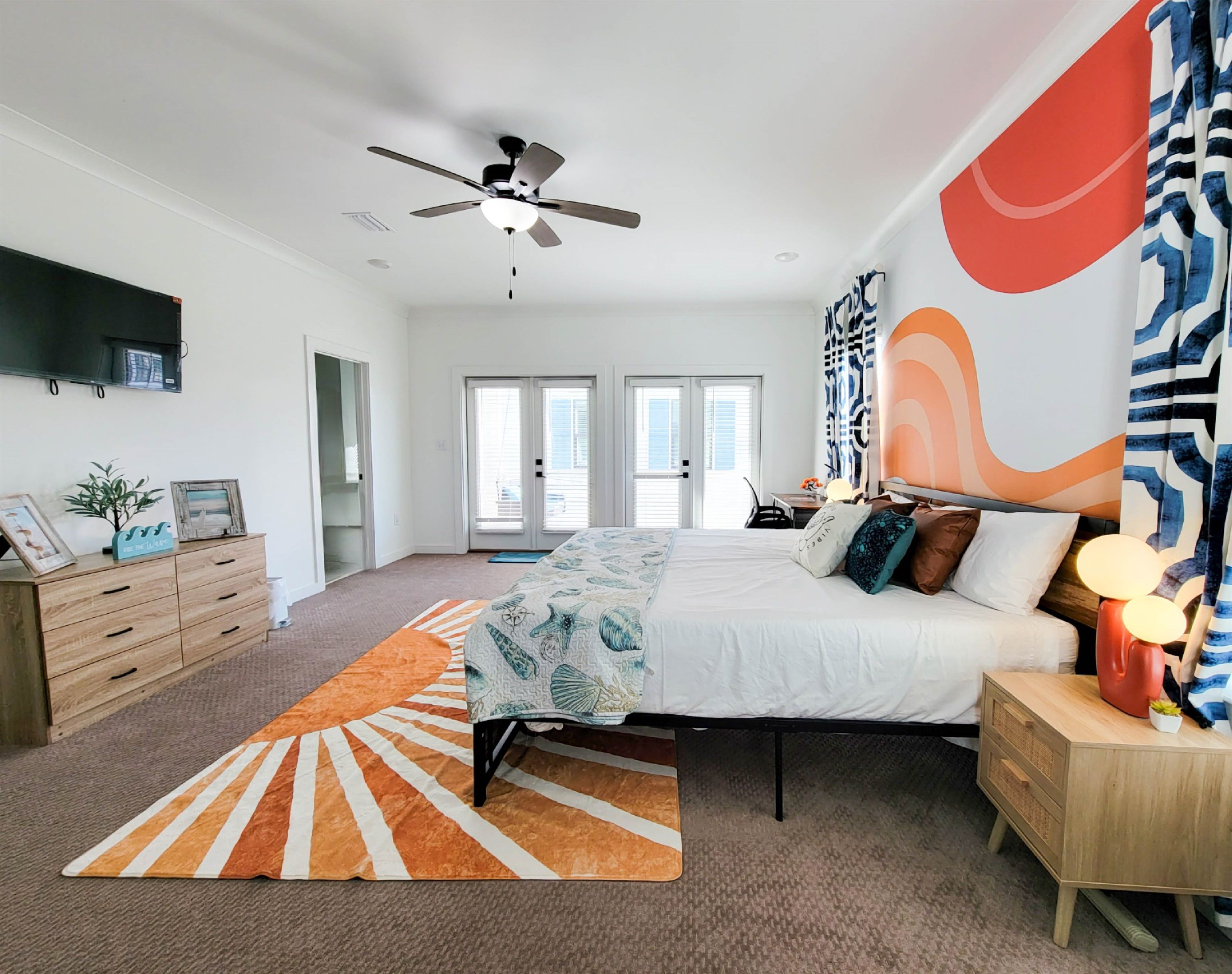 Une chambre à coucher moderne, avec un lit, une table de chevet et un ventilateur de plafond.