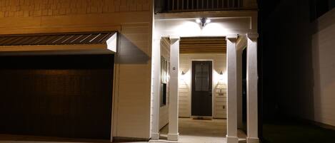 Una casa de dos pisos con un porche cubierto, un garaje y una puerta principal.