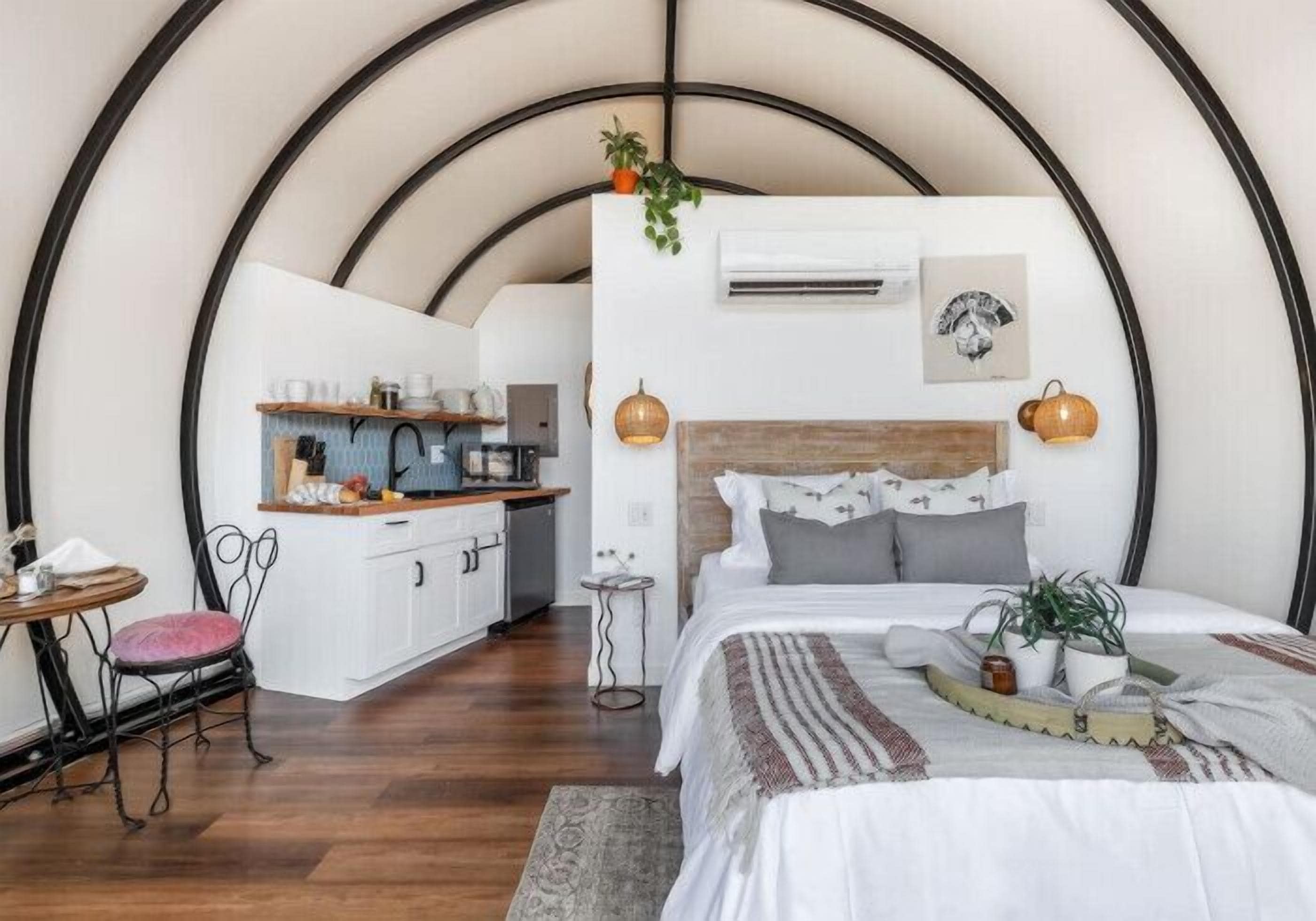 Une chambre confortable avec un lit, une table de chevet et un petit coin salon avec un fauteuil.