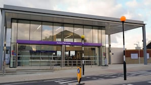 Una estació de tren moderna amb un cartell clar que indica 'Acton Main Line'.