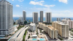 Um complexo hoteleiro com vários edifícios, piscina e vista para o oceano.