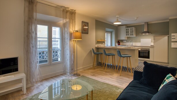 A modern apartment with a living room, dining area, and kitchen. - Appartement T3 de 60 m2 - Centre Historique (Sarlat-la-Canéda)