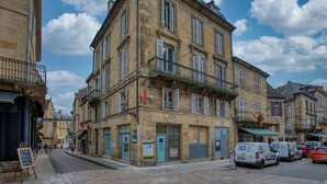 A multi-story building with a traditional European architectural style, featuring balconies and a cobblestone street. - Appartement T3 de 60 m2 - Centre Historique (Sarlat-la-Canéda)