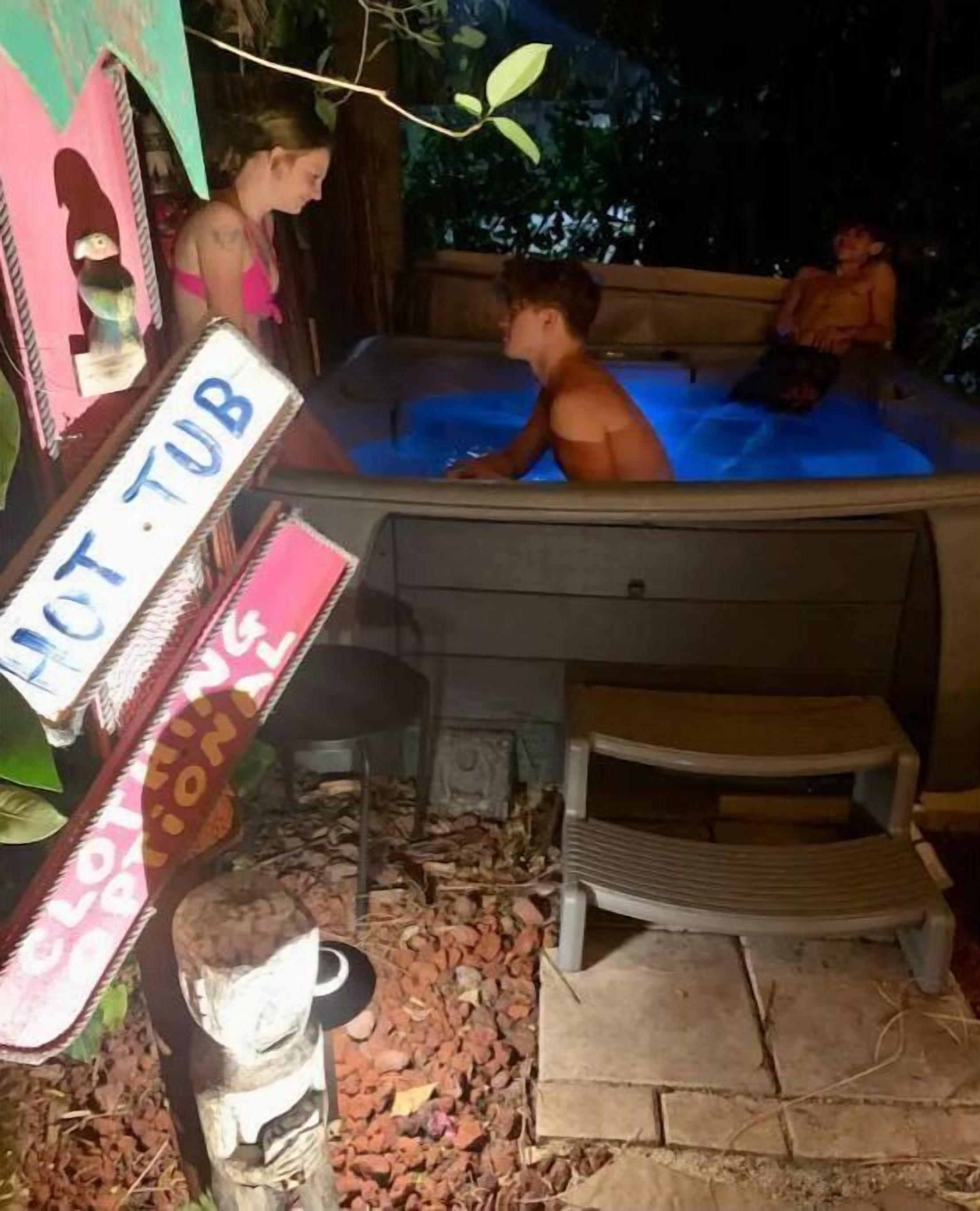 Ein Bereich mit Whirlpool, einem Schild mit der Aufschrift 'HOT TUB' und einer Holzbank.