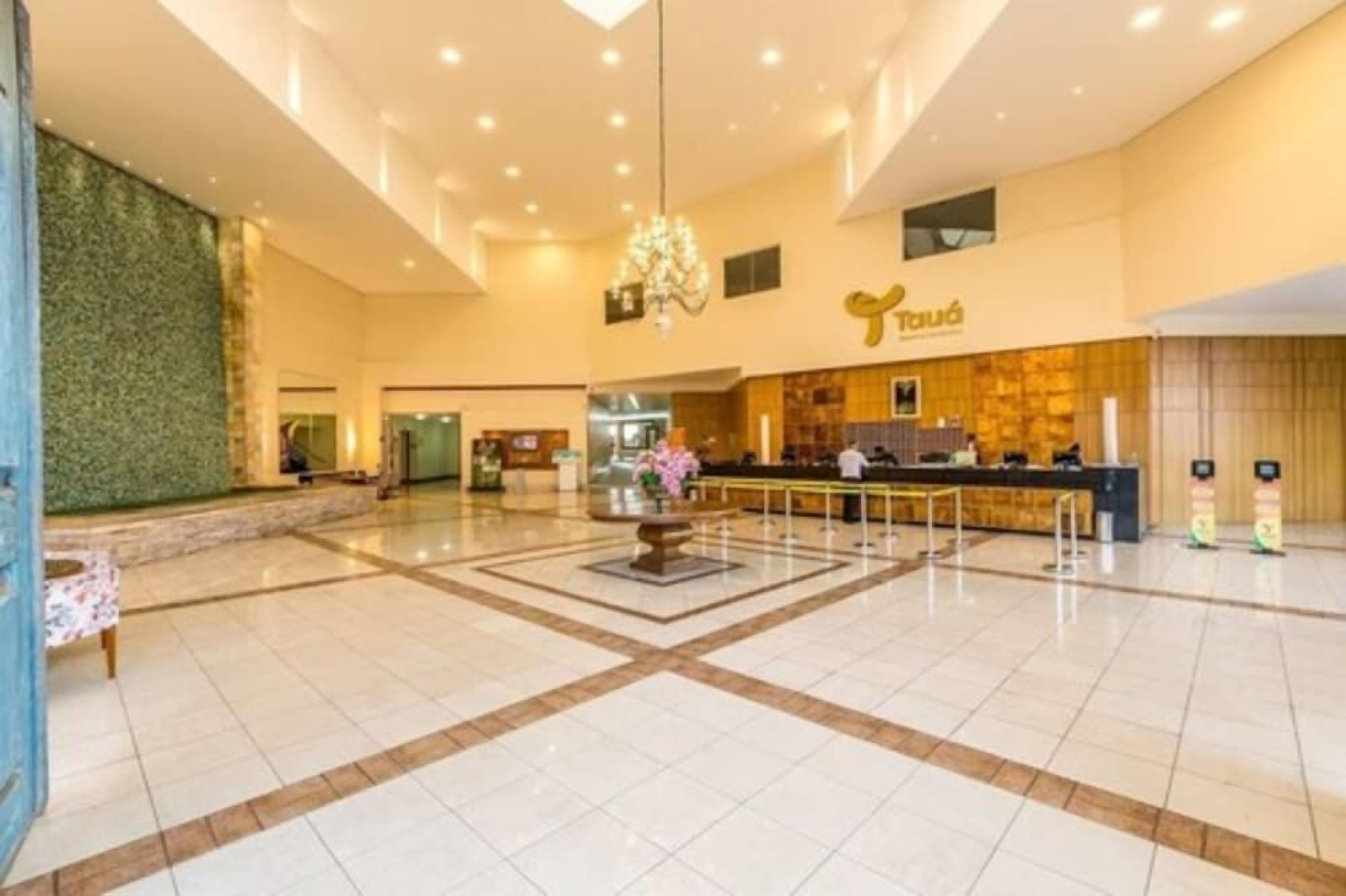 A spacious lobby with a reception desk, a chandelier, and a decorative fountain.