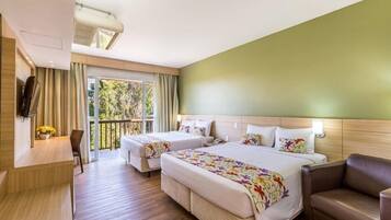 A hotel room with two beds, a desk, a chair, and a balcony with curtains.