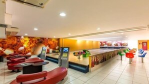 A modern indoor space with red seating, a counter with a colorful mural, and a tiled floor. - Taua Resort & Convention Caete (Caete)