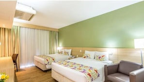 A hotel room with two beds, a sofa, a desk, and a chair. - Taua Resort & Convention Caete (Caete)