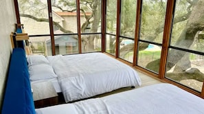 Enjoy a serene view of the surrounding landscape from the large window, featuring two comfortable beds and a convenient bathroom.