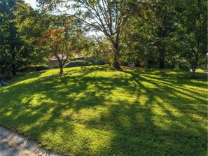 Enjoy a serene lawn surrounded by mature trees.