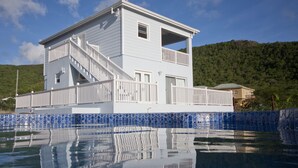 A two-story house with a balcony, a staircase, and a pool with blue tiles. - Close to beach. Peaceful location. Private pool. (St Mary's)