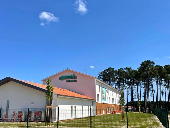 A hotel with a sign reading 'greet hotel,' a red-tiled roof, and a fenced parking area. - greet hotel Castets Coeur des Landes (Castets)
