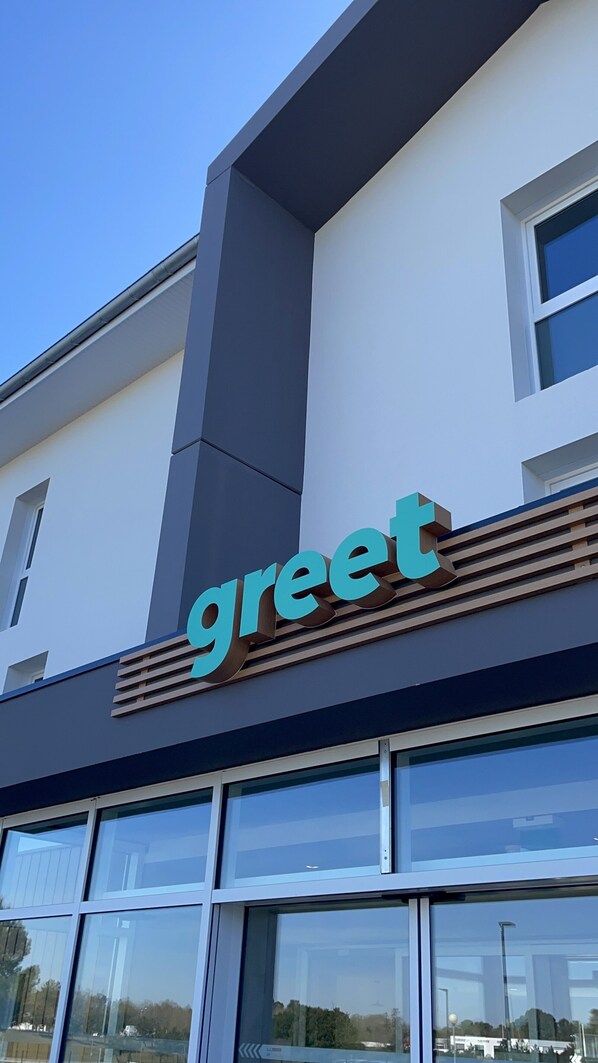 A building with a 'greet' sign on the facade.