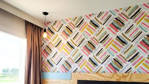 A bedroom with a patterned wallpaper, a wooden headboard, and a large bed with white linens. - greet hotel Castets Coeur des Landes (Castets)