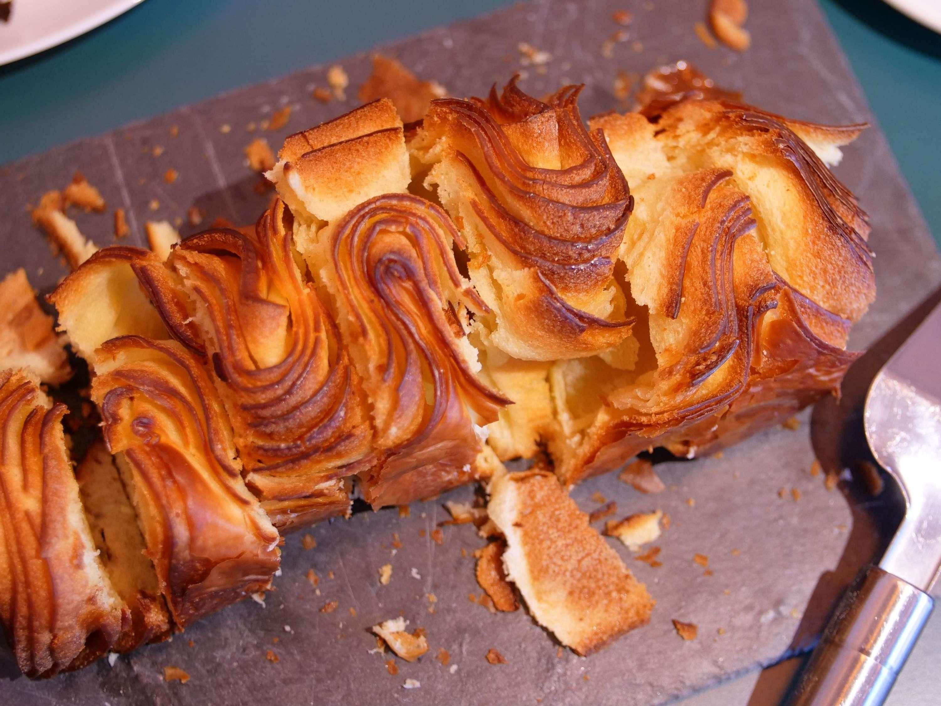 Een brood met een spiraalvormig patroon erop, op een donker oppervlak geplaatst.