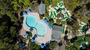 Vista aérea de una propiedad residencial con piscina, zona de patio y jardín ajardinado.