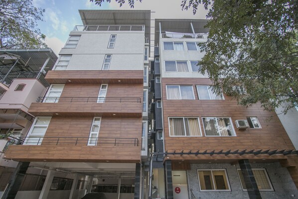 Un edificio residencial de varios pisos con un diseño moderno, que cuenta con balcones y ventanas amplias.