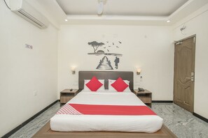 Una habitación de hotel con una cama grande, un mural en la pared, una puerta de madera y un suelo de mármol.