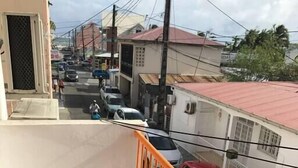 A residential street with parked cars and houses. - Azur apartment with sea view (Sainte-Anne)