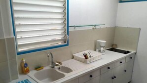 A kitchen with a sink, a coffee maker, and a small countertop. - Azur apartment with sea view (Sainte-Anne)