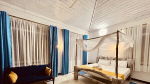 Ein Schlafzimmer mit Baldachinbett, einer Couch und Vorhängen.