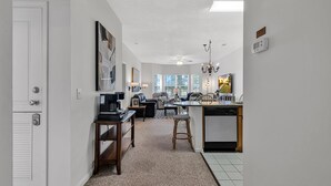 A modern kitchen with a dining area, a coffee machine, and a dishwasher. - Legends Golf Condo Steps From Ailsa Pub & Pool (Myrtle Beach)