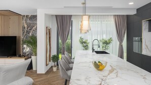 A modern kitchen with a marble countertop, a built-in sink, and a pendant light. - Luxury Villa Moonstone with Pool (Funtana)