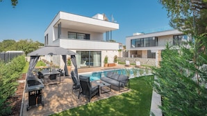 A modern two-story house with a swimming pool, outdoor seating, and a barbecue area. - Luxury Villa Moonstone with Pool (Funtana)