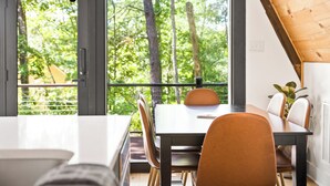 A dining area with a table and chairs, large windows with a view of trees, and a wooden ceiling. - 1 mile to Bryce Resort l 4 BR l Hot Tub l Fire Pit l Game Room  (Basye)