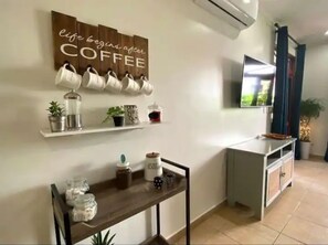 Enjoy a perfectly organized coffee station with a flat-screen TV and ample storage.