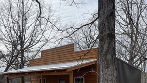 A wooden cabin with a porch, a door, and a window. - Country Cabin with Jacuzzi Tub and Meramec River Access and Pets welcome! (Bourbon)