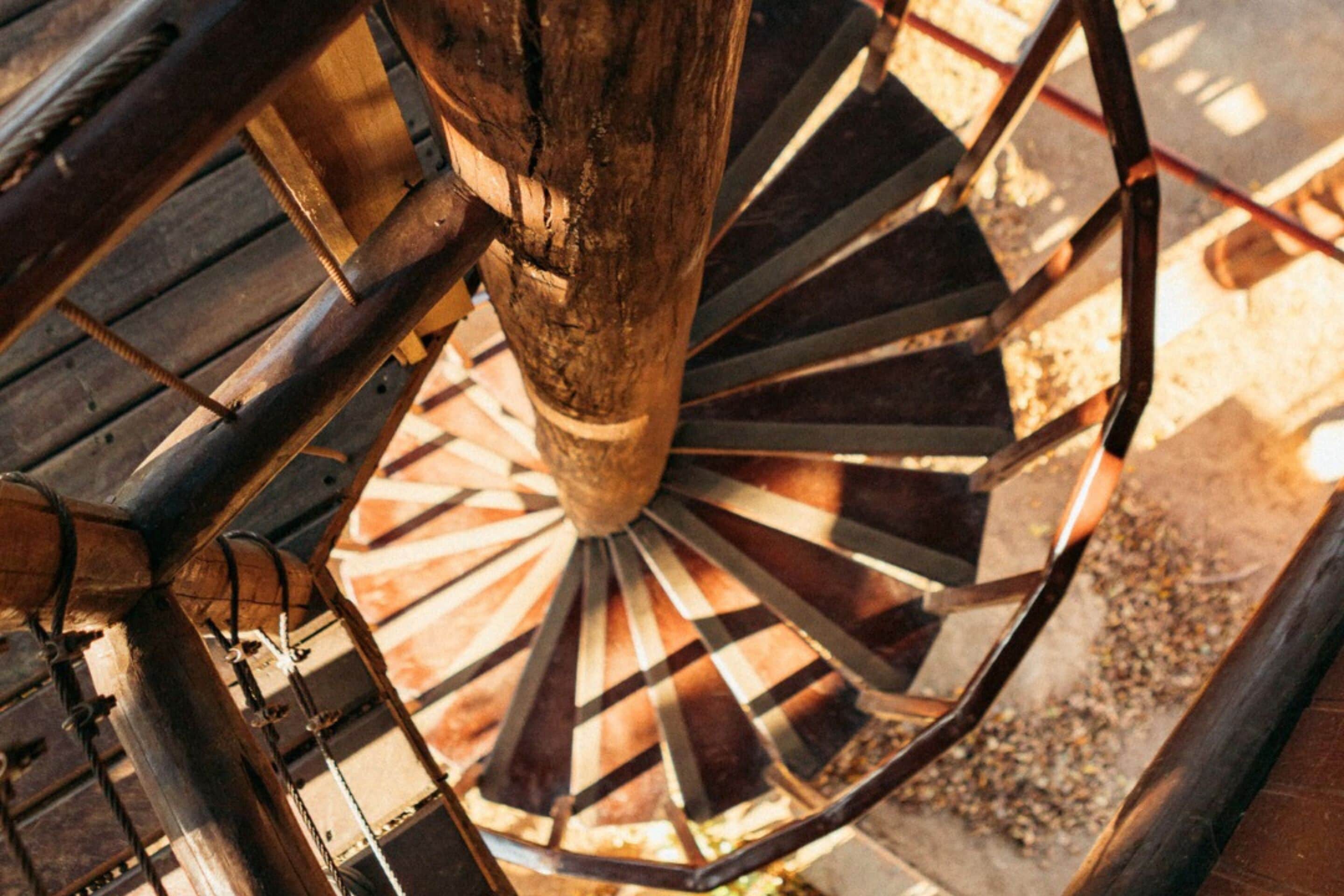Eine Wendeltreppe mit einer Holzstütze und Metallgeländern.