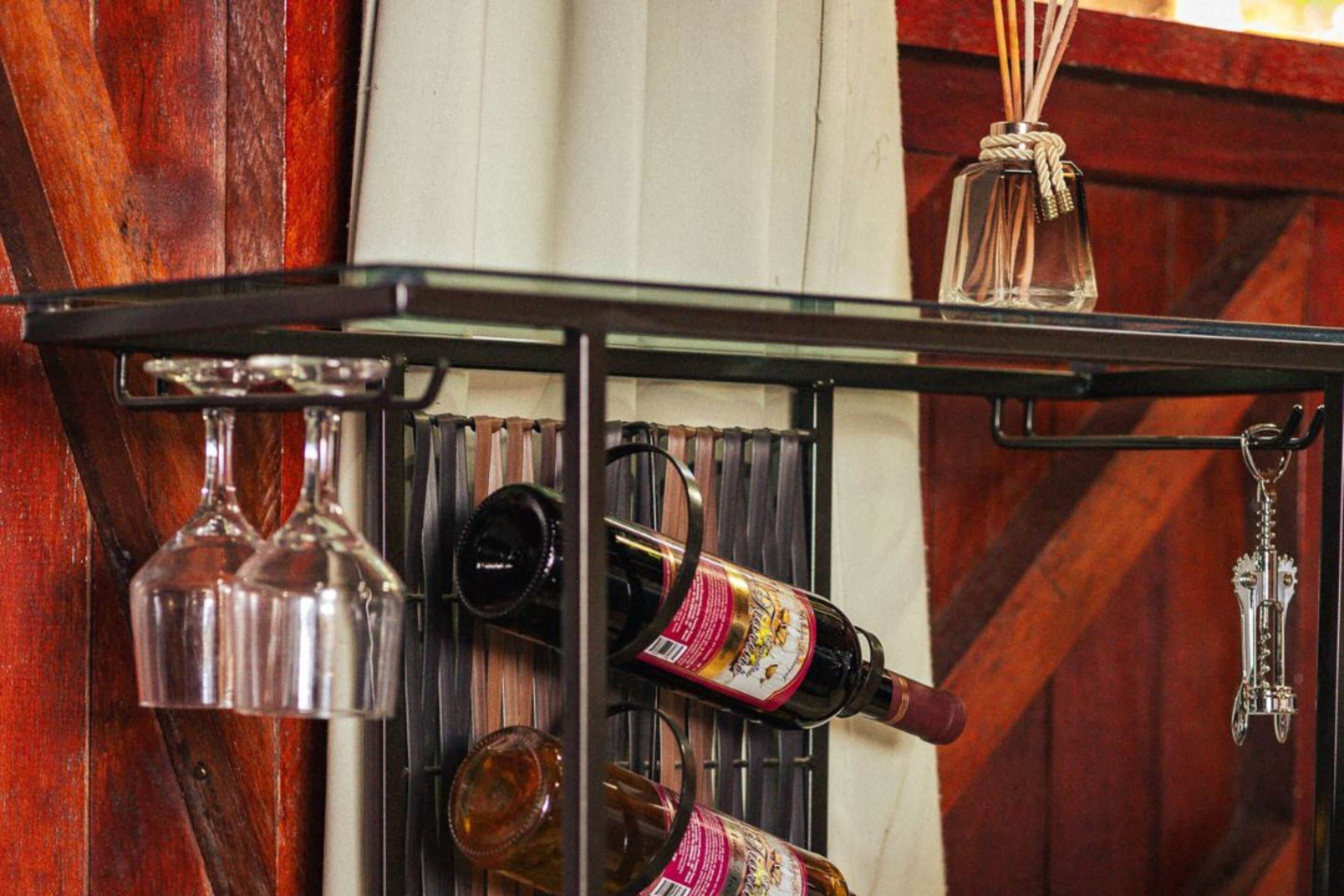 Una botella de vino y copas sobre una pared de madera.