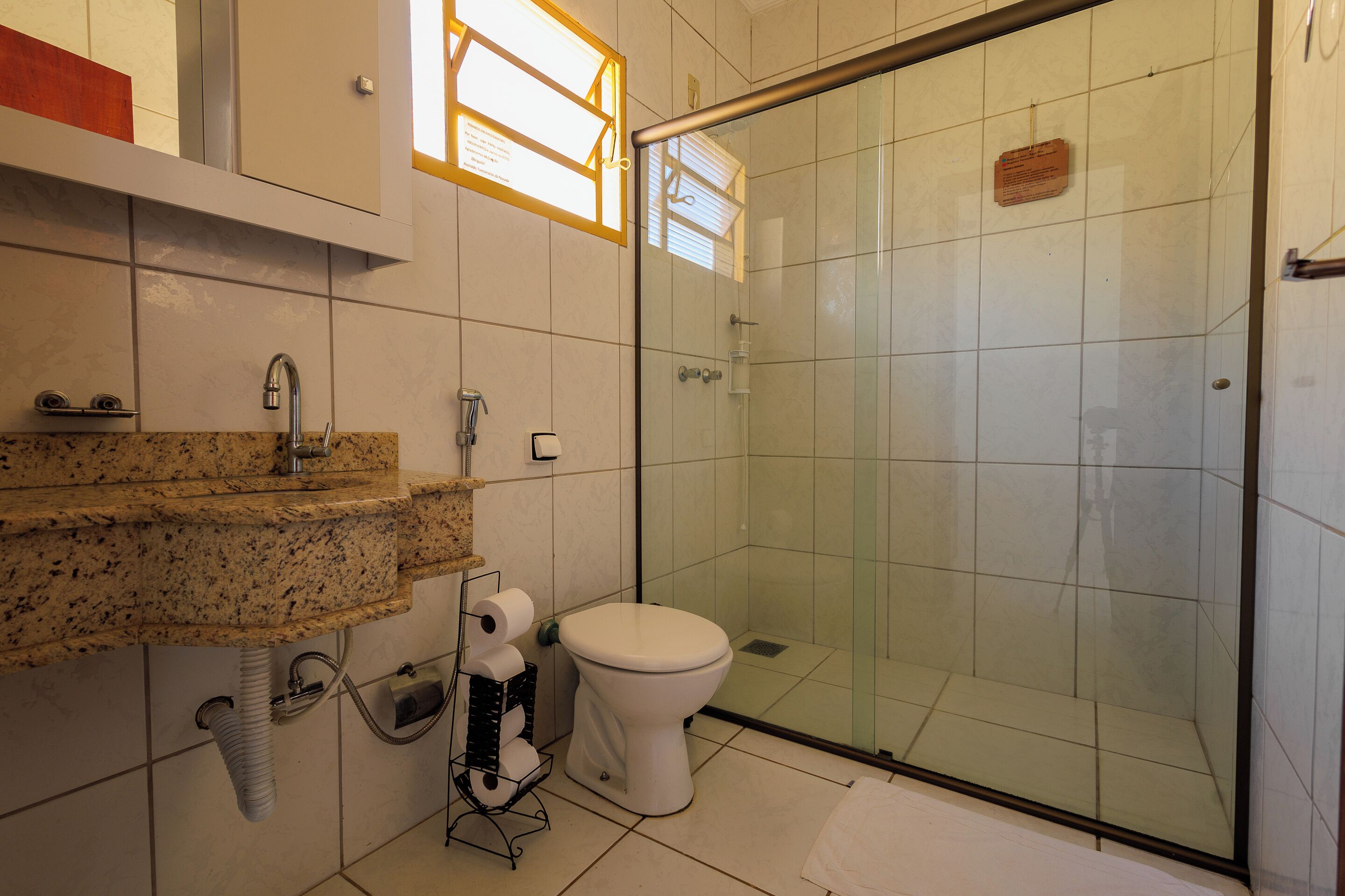 A bathroom with a shower, toilet, and sink.