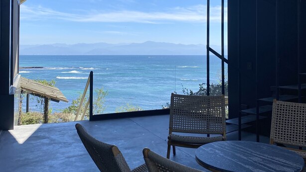 A modern outdoor seating area with wicker chairs and a round table, overlooking a coastal ocean view. - Ocean front house Punta de Mita (Punta de Mita)