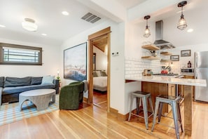 A modern apartment with a living area, kitchenette, and a dining area.