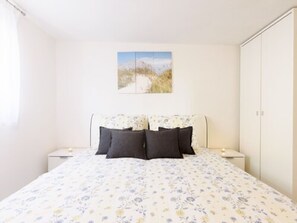 A bedroom with a bed, two bedside tables, a nightstand, a wardrobe, and a painting on the wall. - Apartments Papilon - One Bedroom Apartment with Terrace (Karin Gornji)