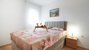 Un dormitorio con cama, una mesita de noche y un cuadro en la pared.