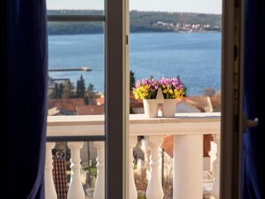 Un balcon avec vue sur une étendue d’eau et un pont au loin.