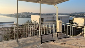 Un balcón con vista a un río y al paisaje urbano.