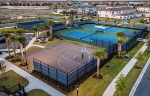 Residents can enjoy a game of basketball or tennis on the enclosed courts surrounded by lush greenery and palm trees.